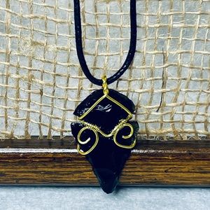 Handmade Wire-Wrapped Obsidian Arrowhead Pendant on faux leather cord necklace.